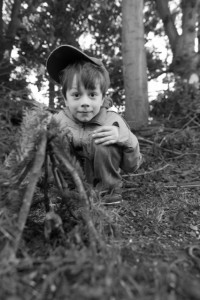 Kind kauernd im Wald